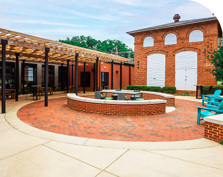 The Hurt Hub brick patio with seating under a pergola