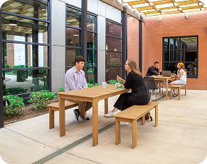 People working at outdoor tables on the Hurt Hub patio