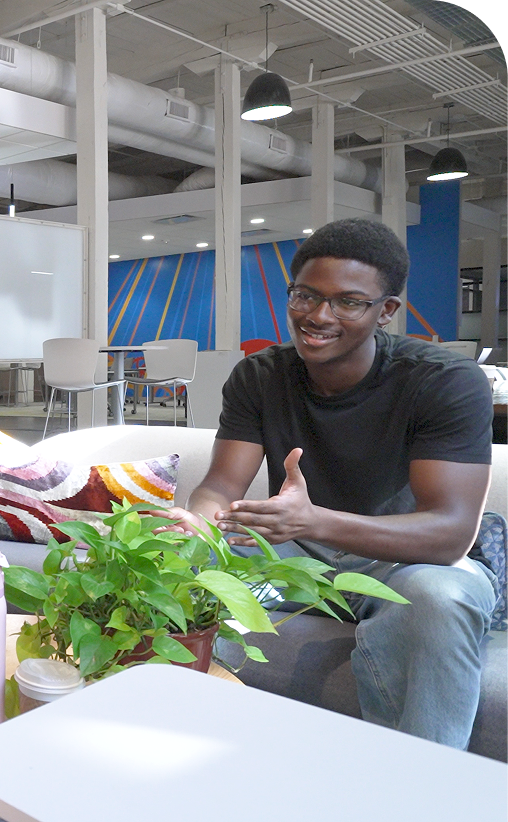 A student talking with someone across a low table