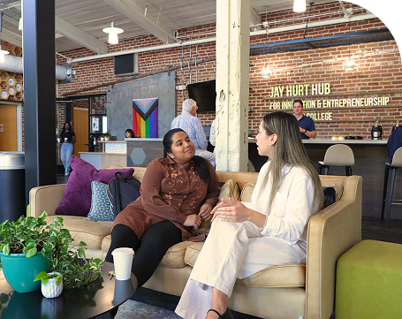Two students talking on a sofa in Social Commons