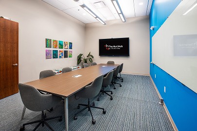 Event Room 302 — a boardroom table with ten chairs and a wall-mounted display